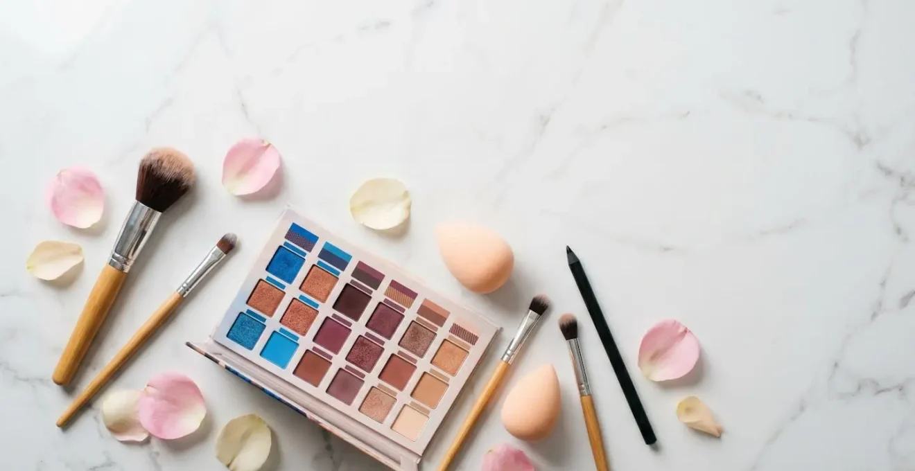 Palette de fards à paupières colorés et pinceaux professionnels sur fond épuré avec reflets naturels