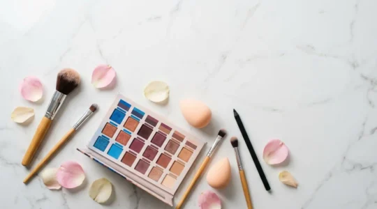 Palette de fards à paupières colorés et pinceaux professionnels sur fond épuré avec reflets naturels